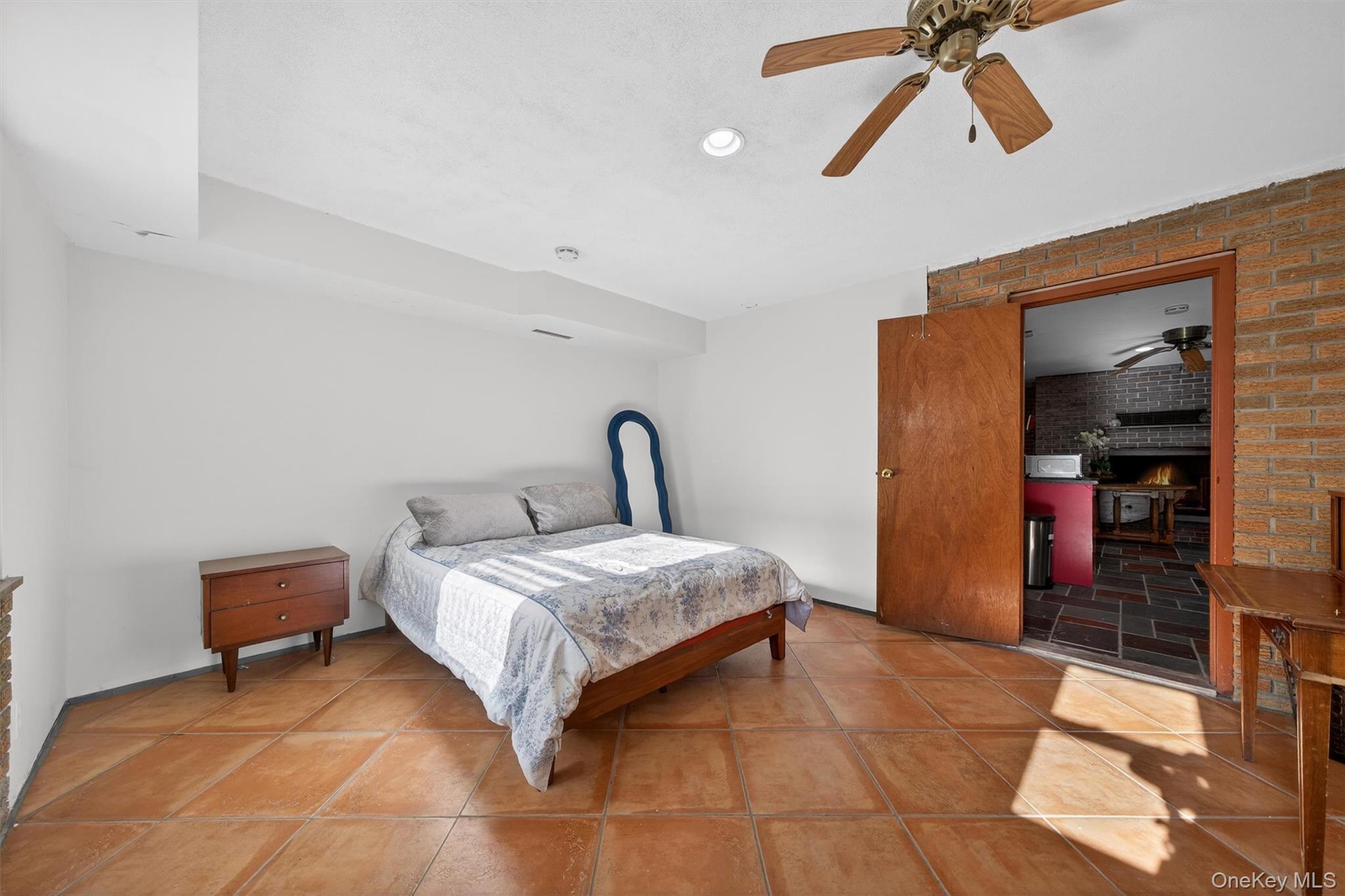 125 Dexheimer Road Narrowsburg, NY 12764 - Photo 34 of 50 Bedroom with a fireplace, a ceiling fan, recessed lighting, and brick wall