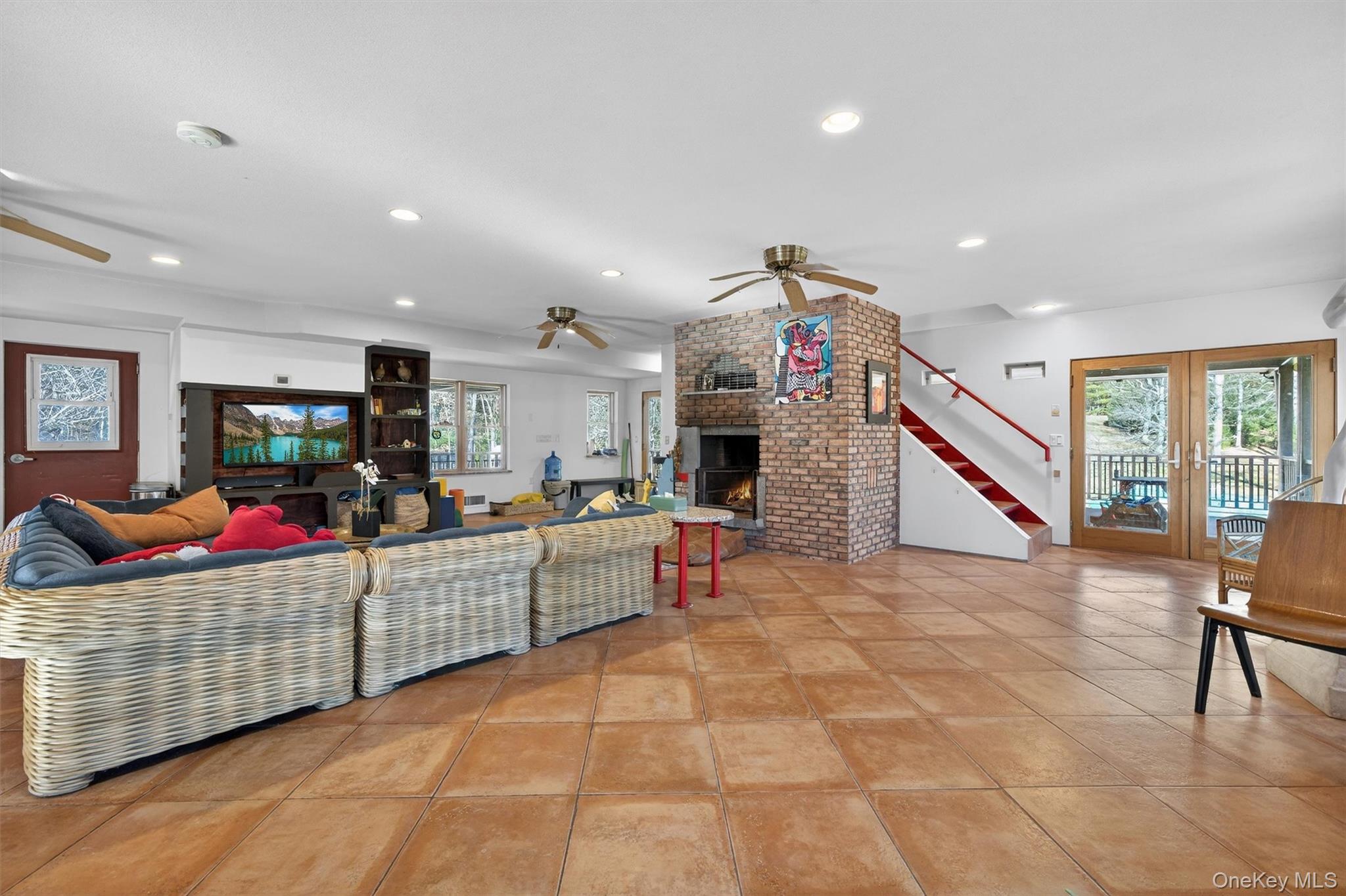 125 Dexheimer Road Narrowsburg, NY 12764 - Photo 6 of 50 Living room with stairway, recessed lighting, healthy amount of natural light, a brick fireplace, and light tile patterned floors