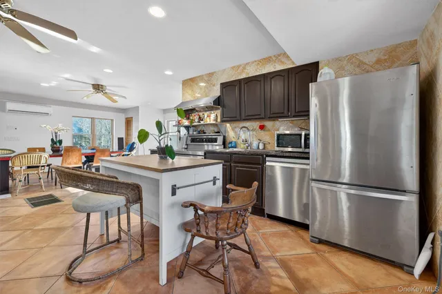 a kitchen with stainless steel appliances a refrigerator a stove a sink dishwasher and a refrigerator with wooden floor