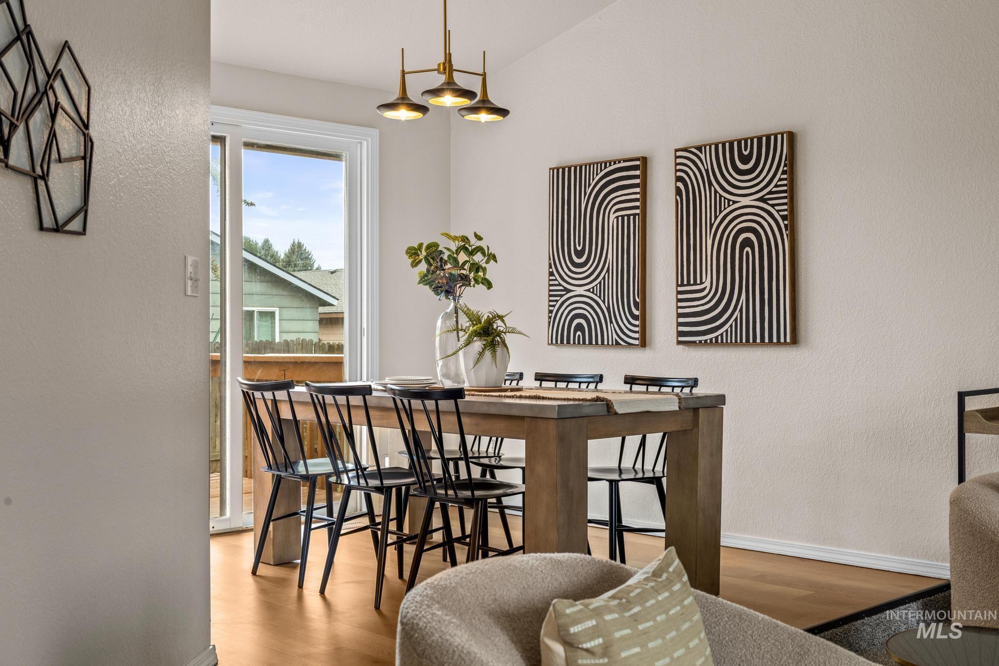 4745 North Oxbow Place Boise, ID 83713 - Photo 11 of 38 Dining room featuring wood finished floors, a textured wall, and lofted ceiling