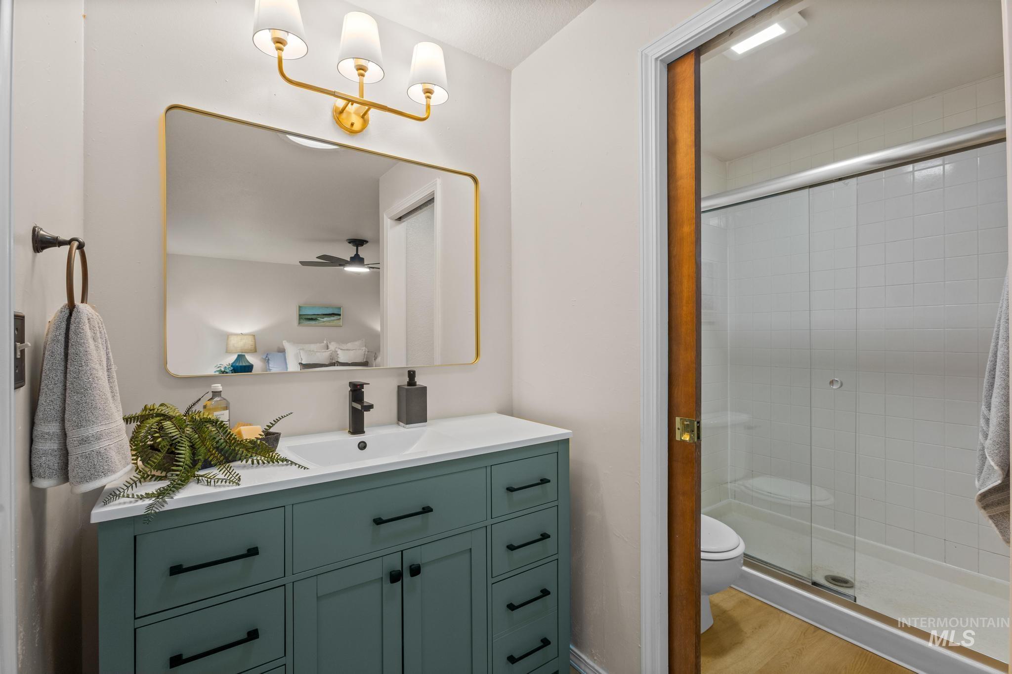 4745 North Oxbow Place Boise, ID 83713 - Photo 25 of 38 Full bathroom featuring vanity, a stall shower, and light wood finished floors