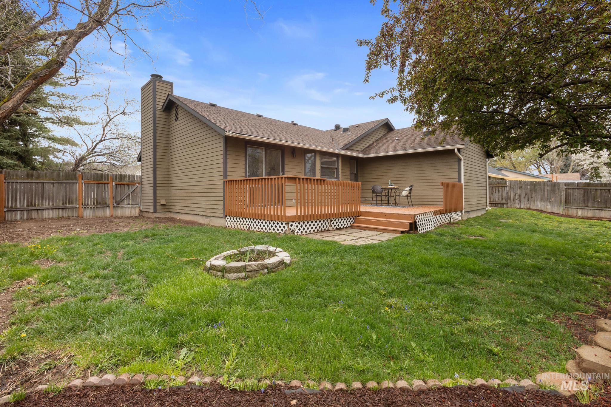 4745 North Oxbow Place Boise, ID 83713 - Photo 34 of 38 Rear view of property featuring a fenced backyard, a deck, an outdoor fire pit, a chimney, and roof with shingles