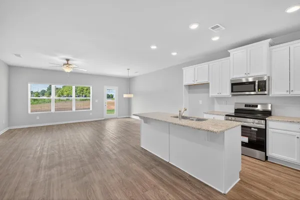 a kitchen with stainless steel appliances granite countertop a stove a sink and a microwave