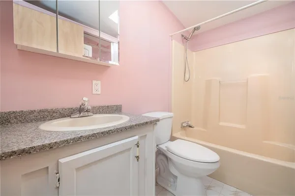 a bathroom with a granite countertop sink a toilet and a bathtub