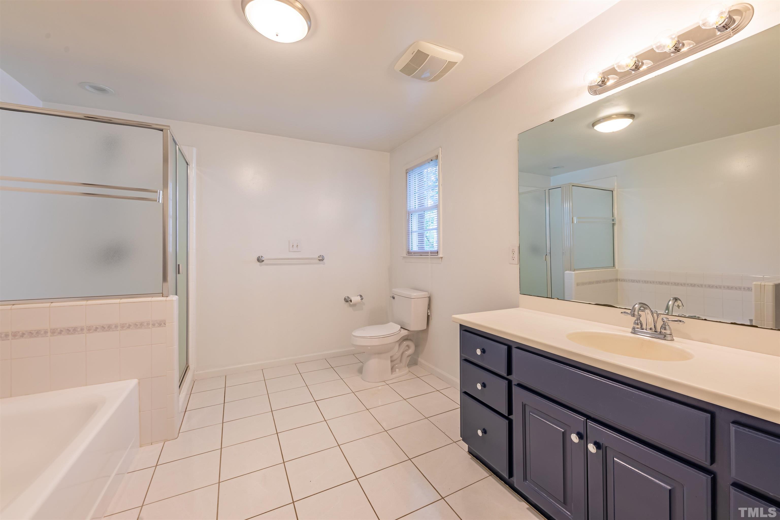 1511 Duplin Road Raleigh, NC 27607 - Photo 13 of 23 a spacious bathroom with a double vanity sink toilet mirror and bathtub