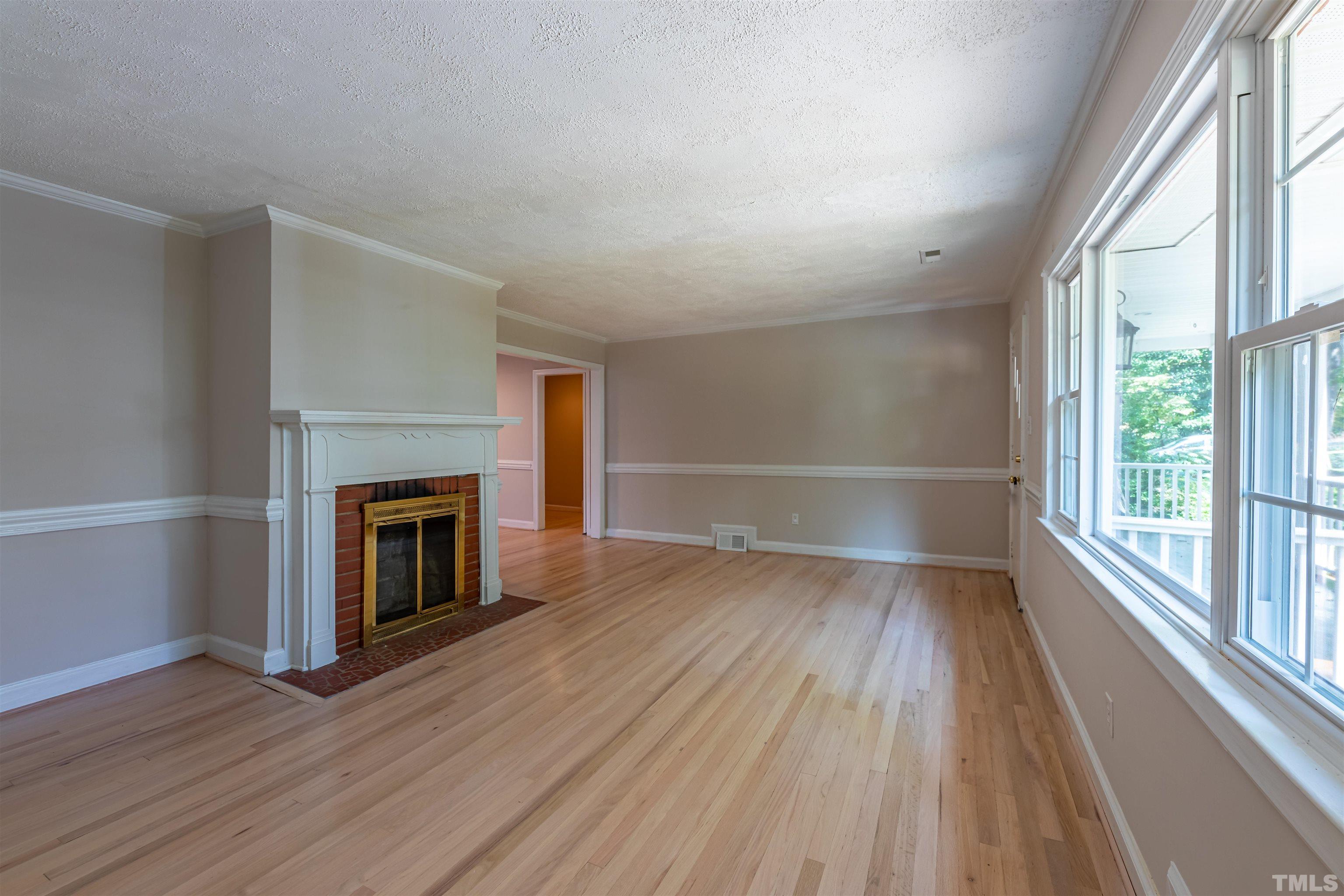 1511 Duplin Road Raleigh, NC 27607 - Photo 3 of 23 a view of empty room with wooden floor and fireplace