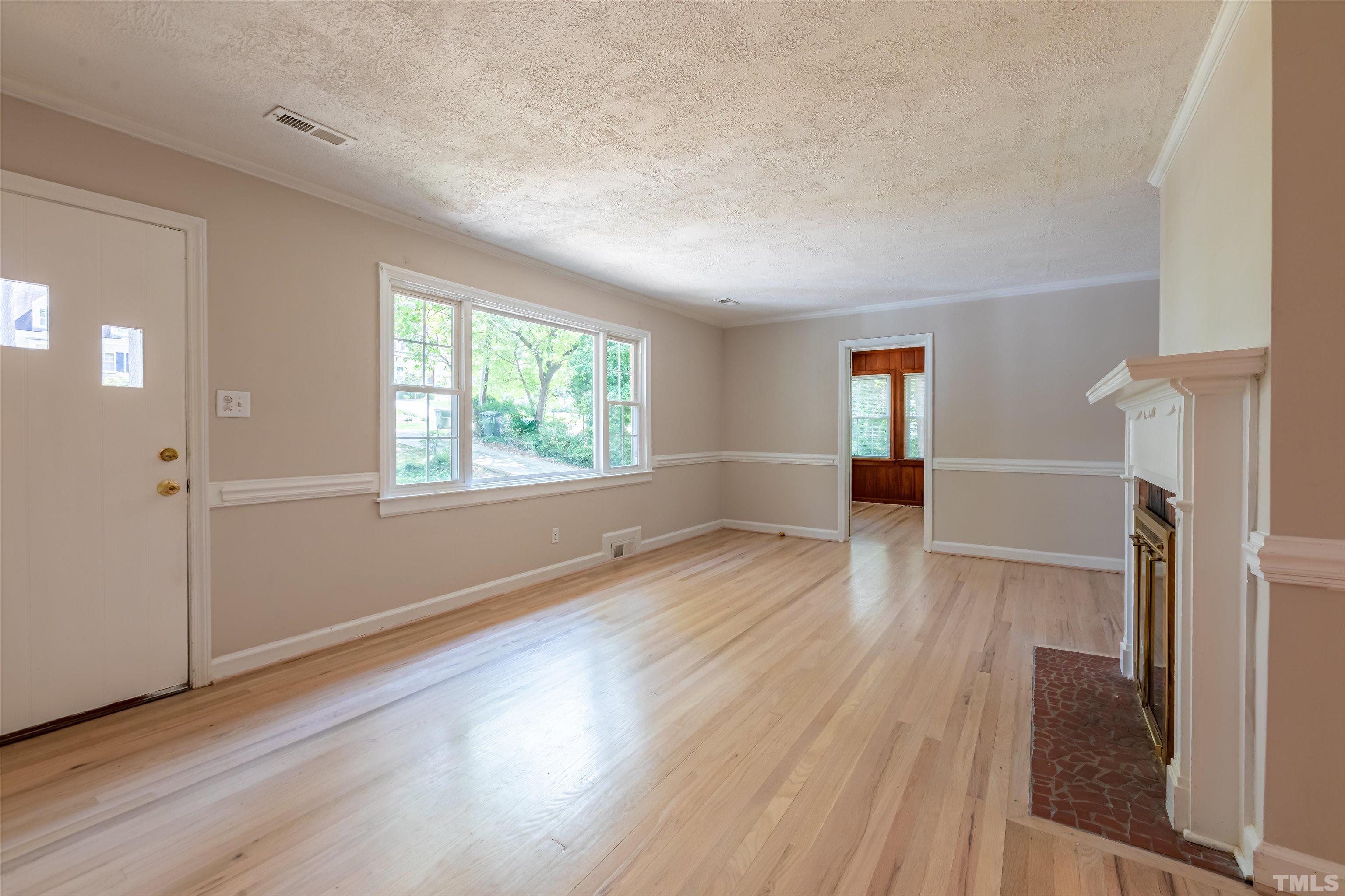 1511 Duplin Road Raleigh, NC 27607 - Photo 4 of 23 an empty room with wooden floor and windows