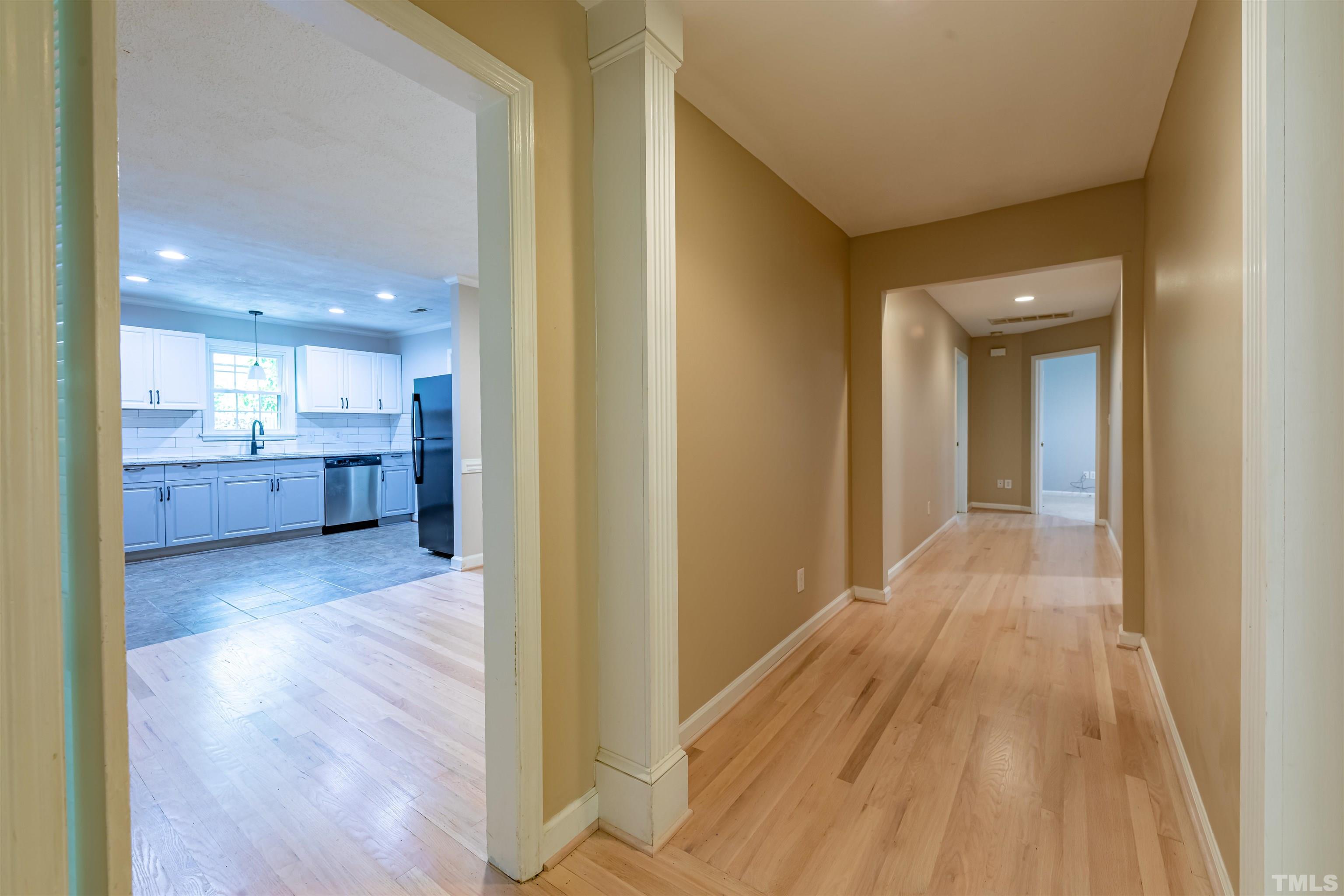 1511 Duplin Road Raleigh, NC 27607 - Photo 9 of 23 a view of a hallway with wooden floor and kitchen