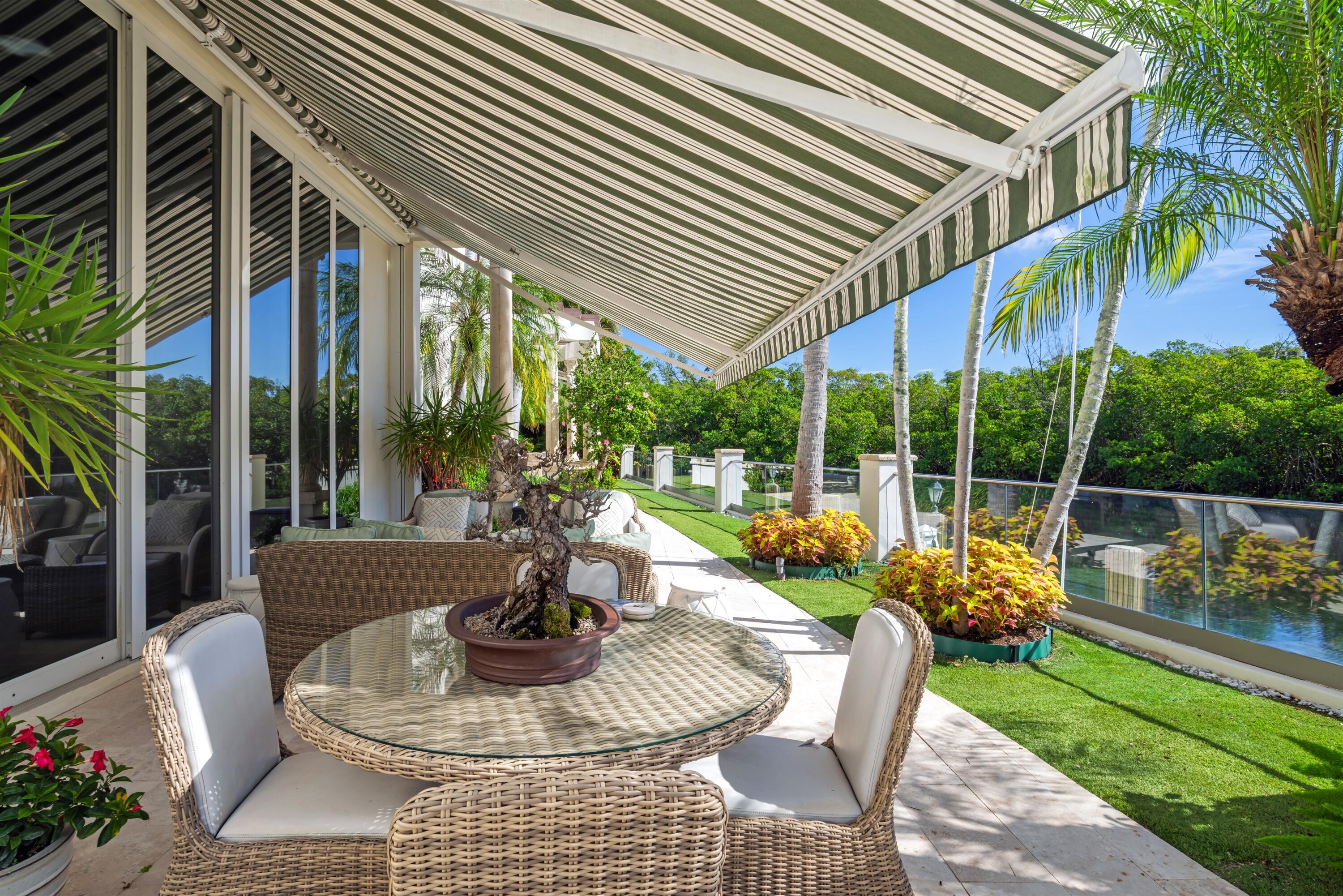 799 Northeast 45th Road Boca Raton, FL 33431 - Photo 27 of 90 a view of a patio with couches table and chairs potted plants and palm trees