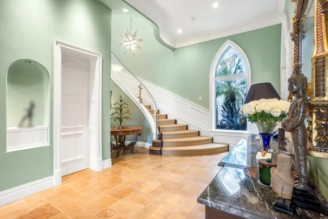 a living room with stainless steel appliances kitchen island granite countertop a table chairs in it and a large window