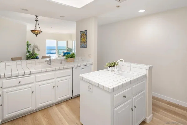 a kitchen with granite countertop a sink stove and white cabinets