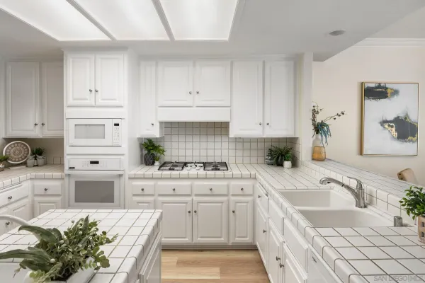 a kitchen with white cabinets and white appliances