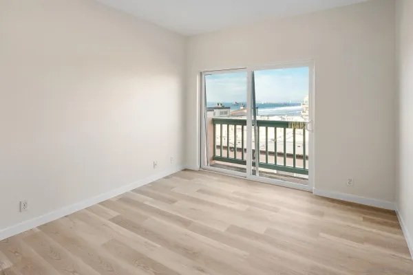 a view of a hallway with wooden floor and windows