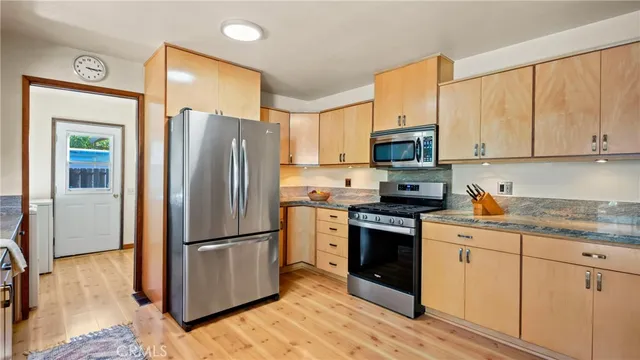 a front view of a house with a yard and tree s