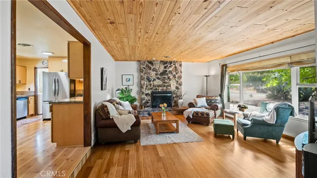 a living room with furniture a fireplace and a floor to ceiling window