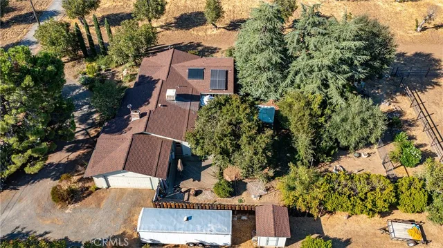 a kitchen with stainless steel appliances granite countertop a refrigerator a stove top oven a sink a dining table and chairs with wooden floor