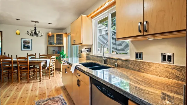 a kitchen with granite countertop a refrigerator stove top oven and sink