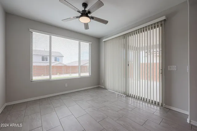 an empty room with windows and fan