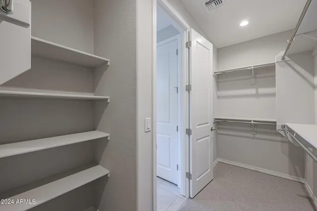 an empty room with an entryway and fan
