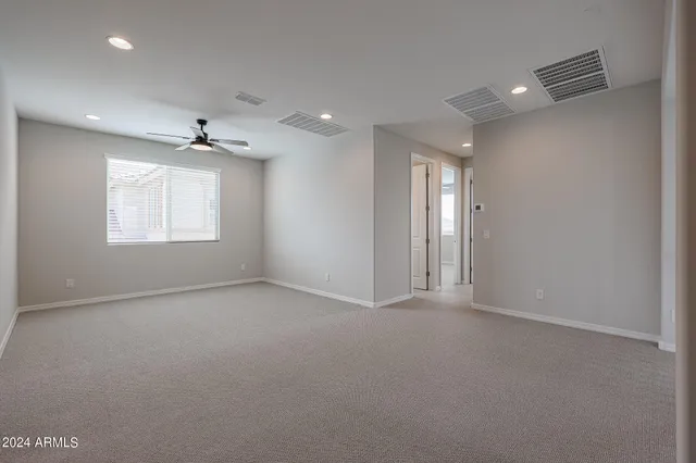 an empty room with a window and a fan