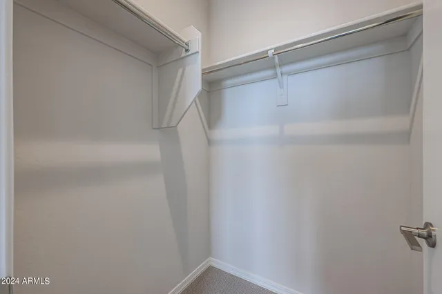 an empty room with closet and windows