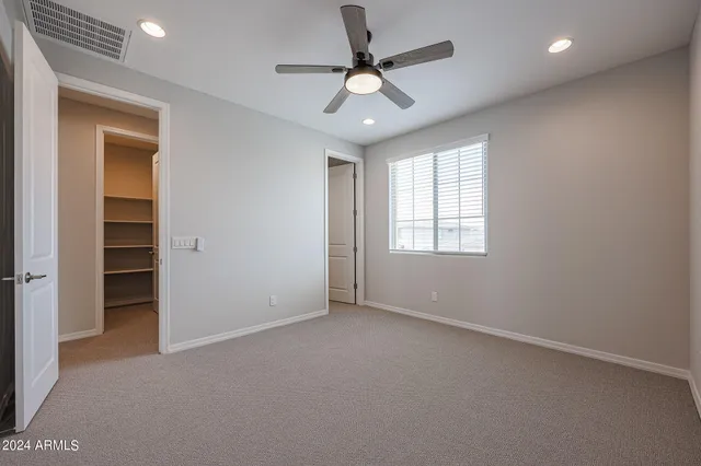 wooden floor in an empty room with a chandelier fan