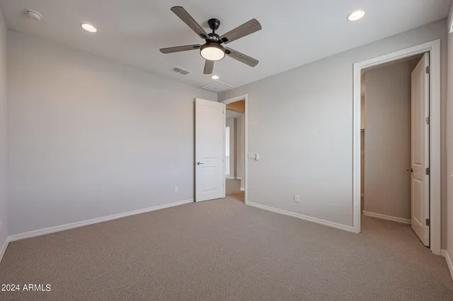 a view of a hallway with a livingroom and a kitchen