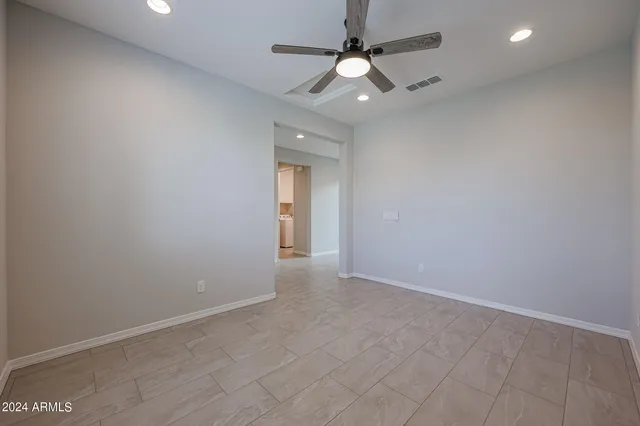 an empty room with a window and a fan