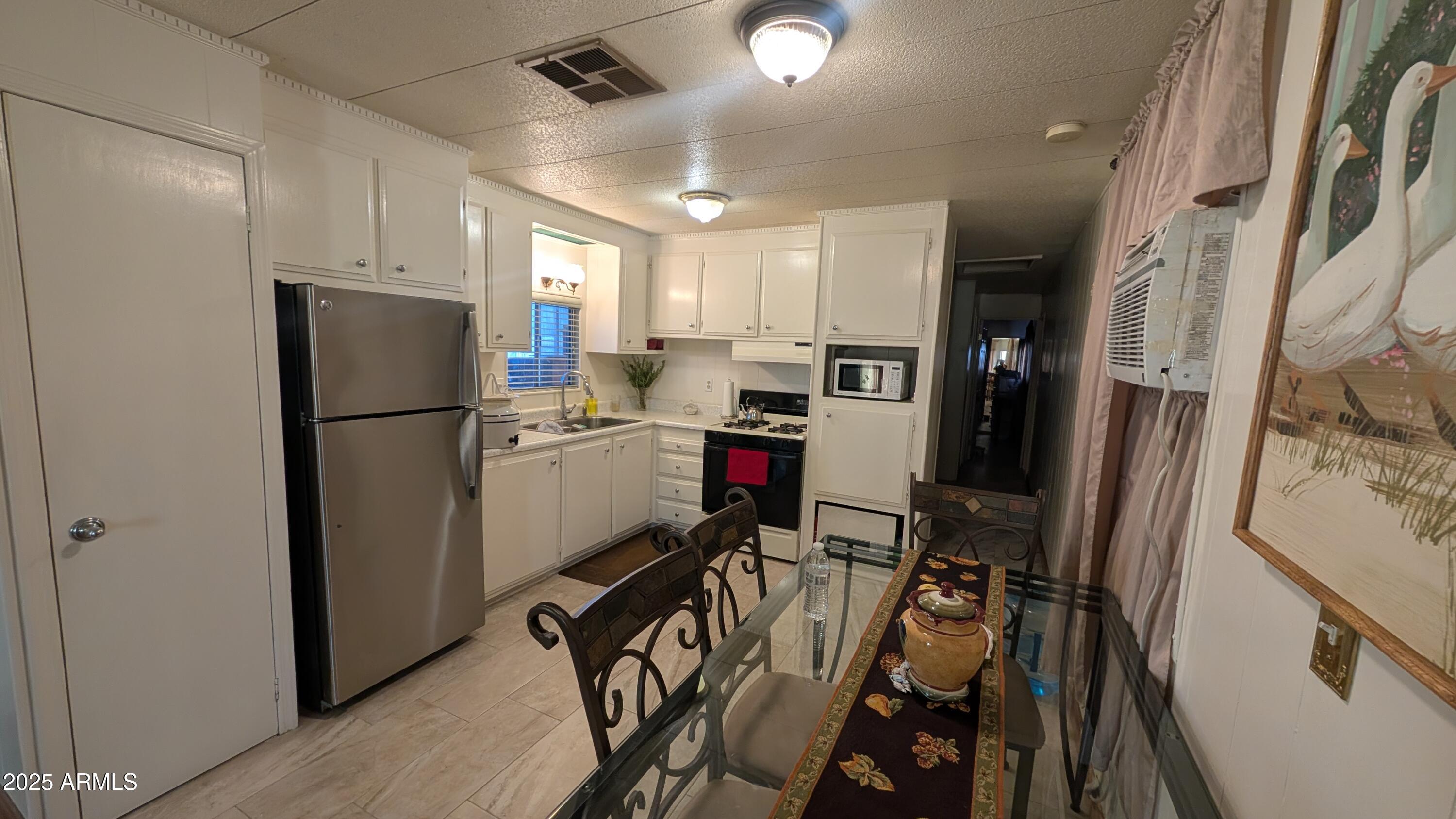 1250 East Bell Road, Unit 23 Phoenix, AZ 85022 - Photo 5 of 26 a kitchen with stainless steel appliances a refrigerator a sink and a stove