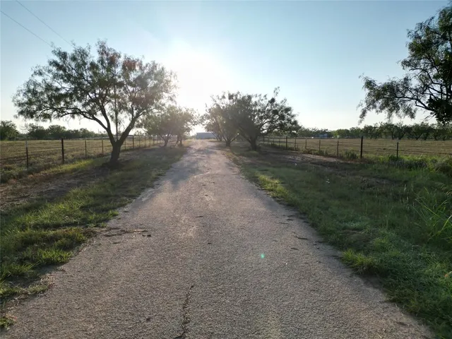 a view of a dirt road with a building in the background