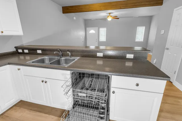 a kitchen with a sink dishwasher and white cabinets
