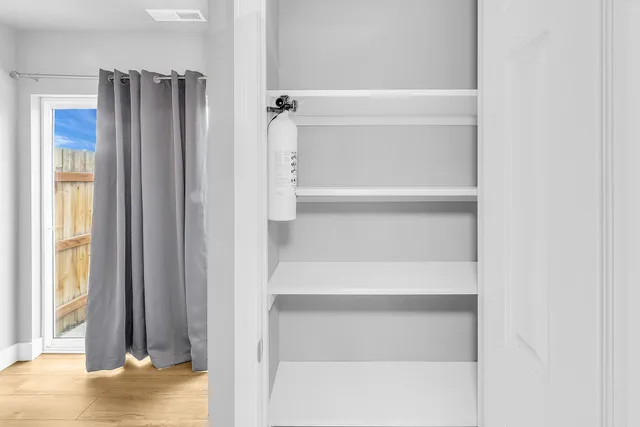 a view of walk in closet with empty racks