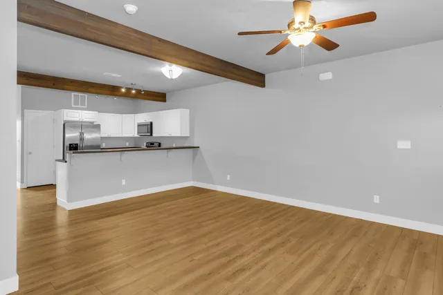 a view of a kitchen with a sink and a chandelier fan