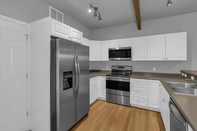 a kitchen with stainless steel appliances granite countertop a stove a refrigerator and a sink