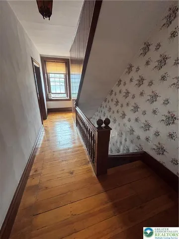 a view of a hallway with wooden floor and staircase