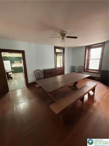 a living room with hardwood floor pool table and windows
