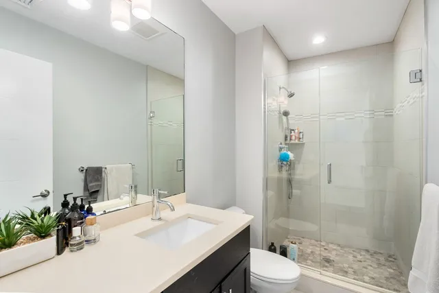 a bathroom with a sink a toilet and shower