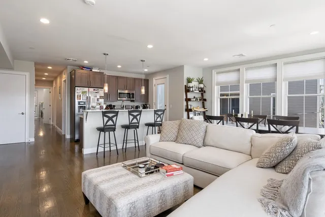 a living room with furniture and view of kitchen
