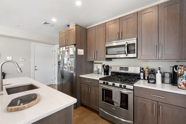 a kitchen with granite countertop a sink stove and refrigerator