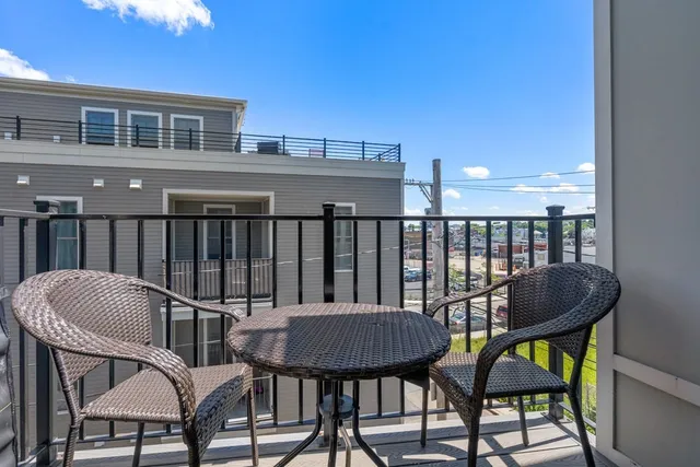 a balcony with a table and chairs