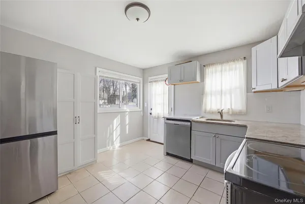 a kitchen with white cabinets and refrigerator