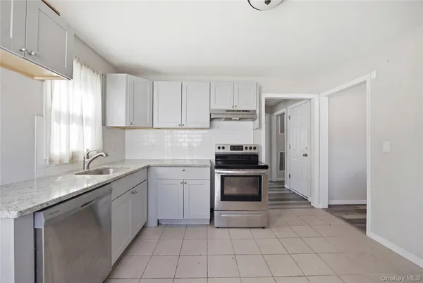 a kitchen with granite countertop a sink stove and cabinets