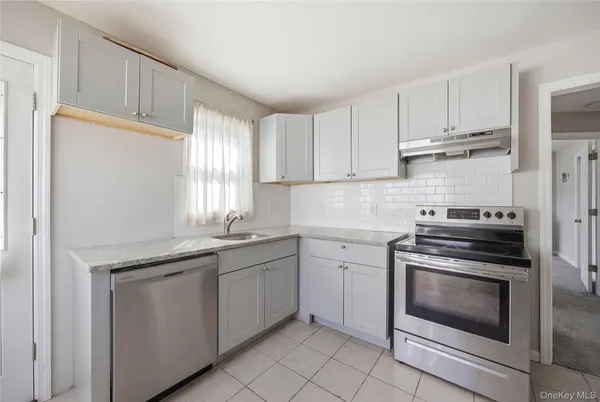 a kitchen with white cabinets and appliances