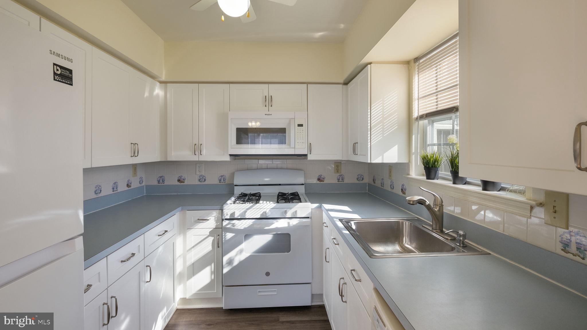 5480 Rinker Circle Doylestown, PA 18902 - Photo 10 of 23 a kitchen with stainless steel appliances a sink a stove and white cabinets