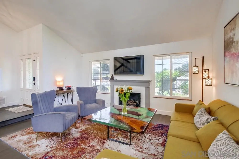 14759 Alando Place Poway, CA 92064 - Photo 5 of 30 a living room with furniture a fireplace a flat screen tv and windows