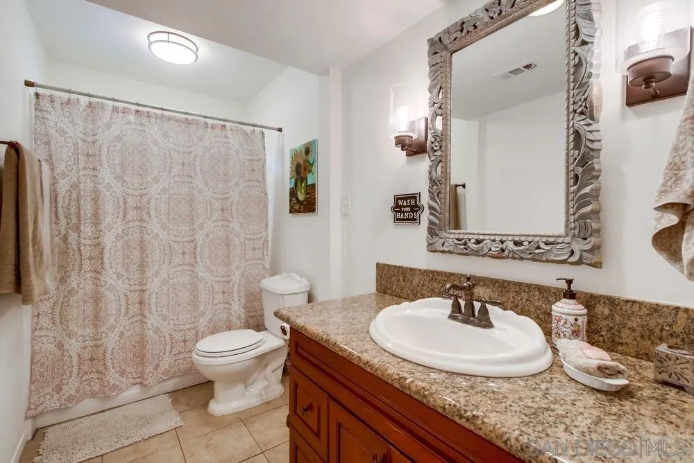 14759 Alando Place Poway, CA 92064 - Photo 10 of 30 a bathroom with a granite countertop sink and a mirror with toilet