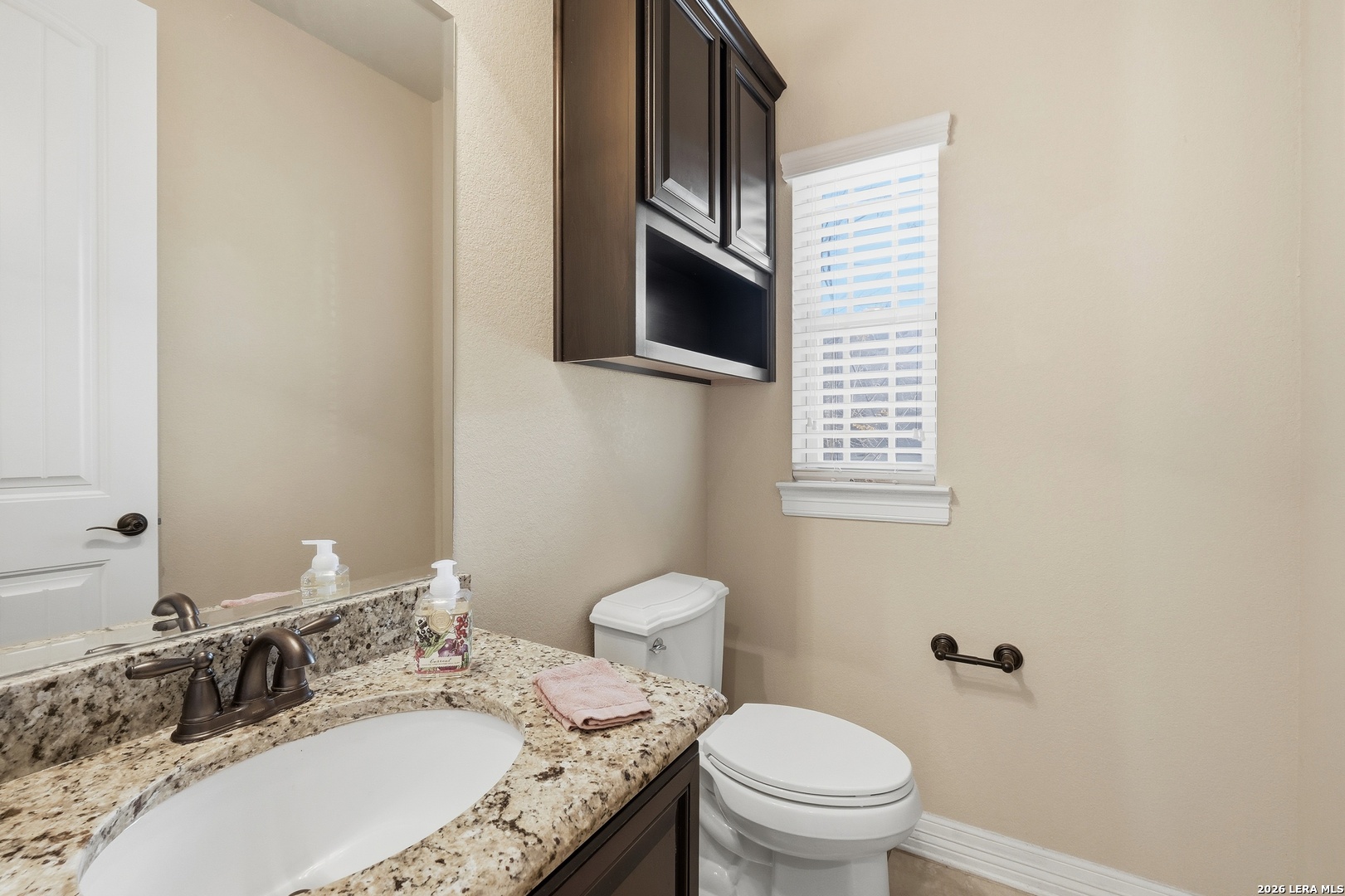 14715 Rifleman Road San Antonio, TX 78254 - Photo 28 of 30 a bathroom with a granite countertop toilet sink and mirror