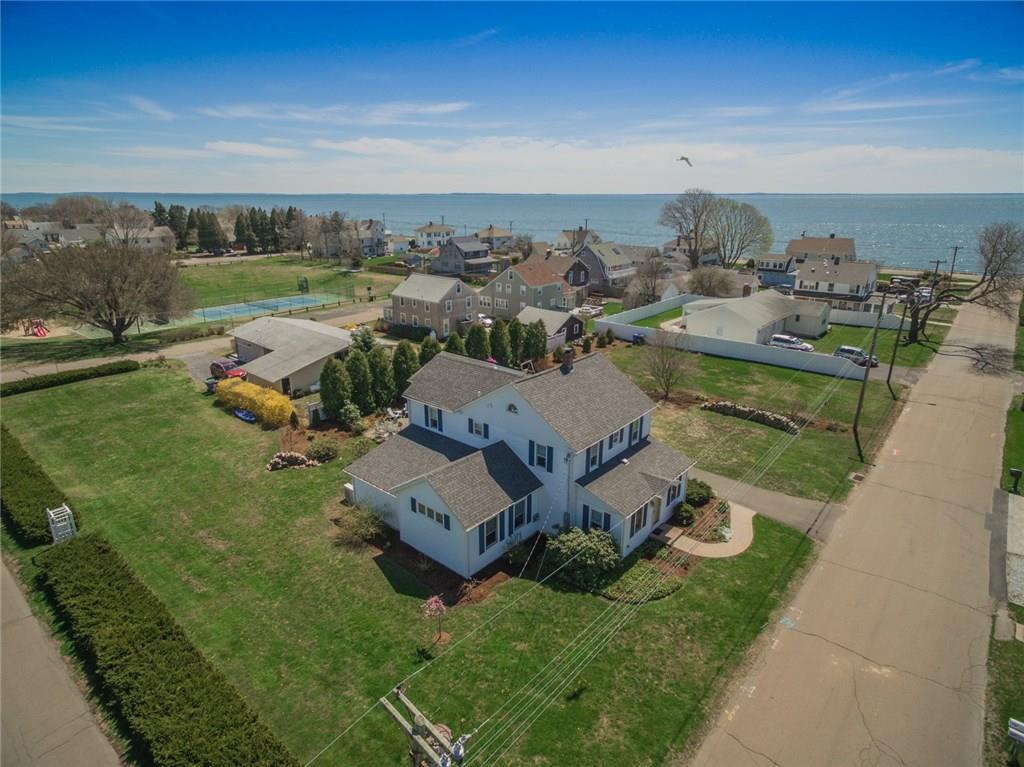 an aerial view of a house with garden space and ocean view in back