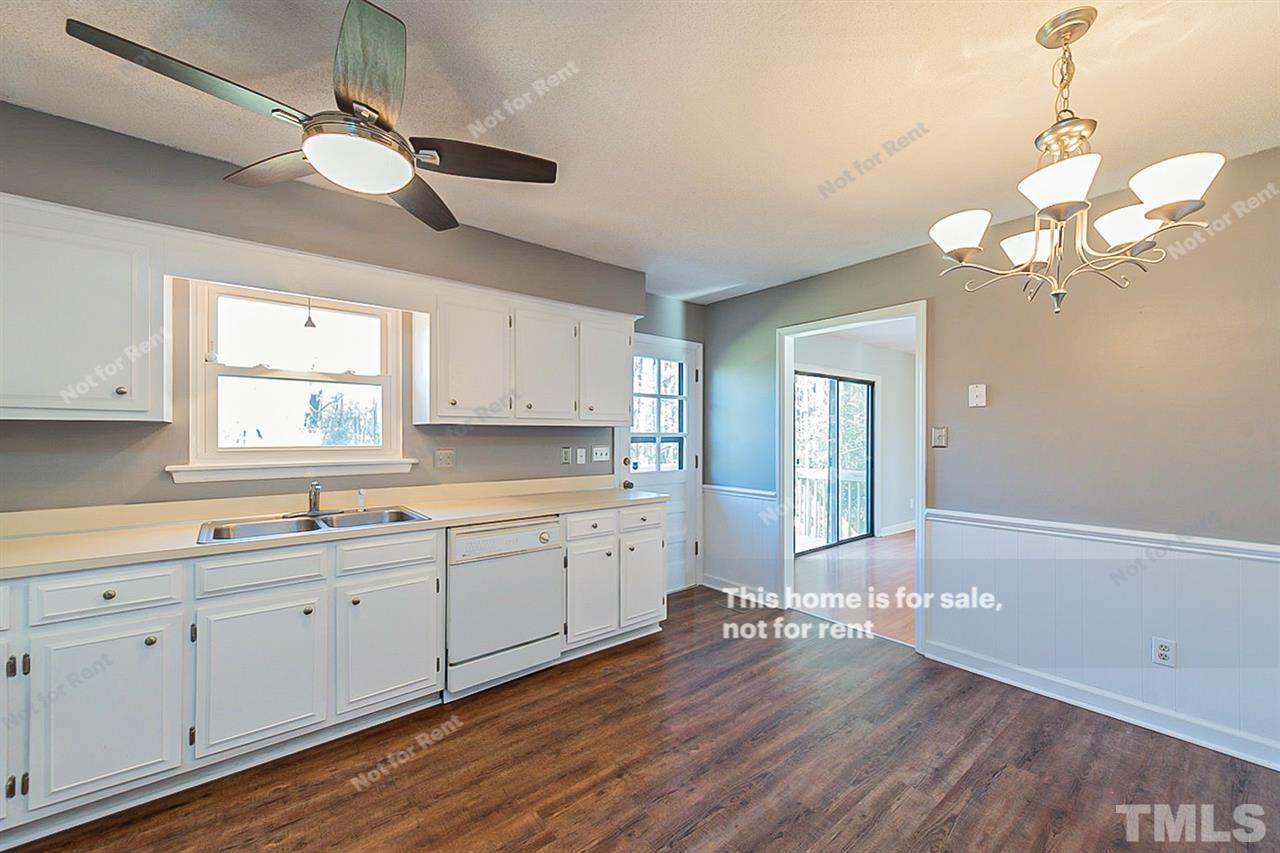 332 Lakeview Road Durham, NC 27712 - Photo 8 of 20 a kitchen with a sink dishwasher a stove and white cabinets with wooden floor