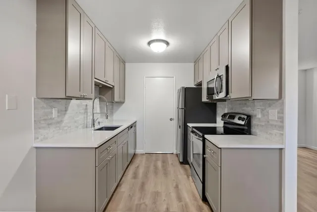 a kitchen with stainless steel appliances granite countertop a sink stove and refrigerator
